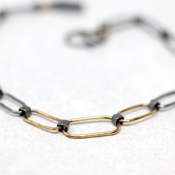 Delicate yet tough flat-link handmade chain bracelet. Handmade double-sided clasp so you can wear tight or slightly loose. Perfect for layering with other bracelets. Bracelet length including clasp is adjustable up to 8 inches.  Bracelet shown in images is blackened sterling silver & buttery 18k gold links. All metals recycled. 
