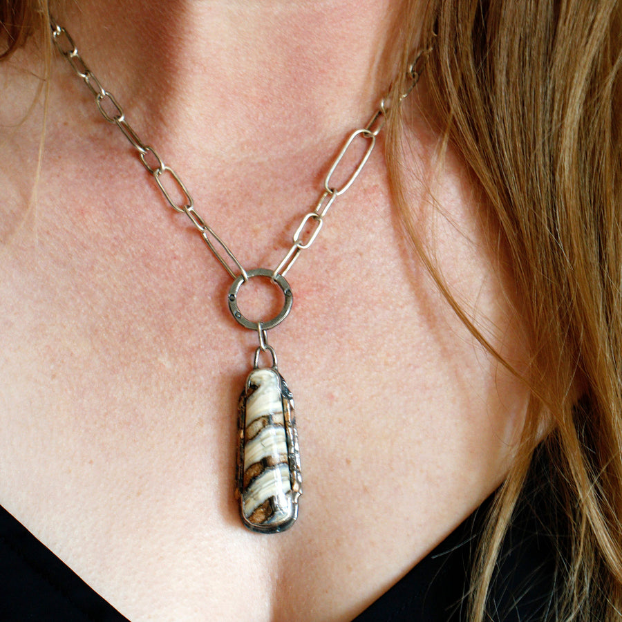 Woolly Mammoth fossil necklace with 14k gold, three black diamonds, and an all handmade sterling silver chain. The fossil itself—a small portion of the molar tooth—is from 14,000-60,000 years ago on the North American continent in Washington state. 